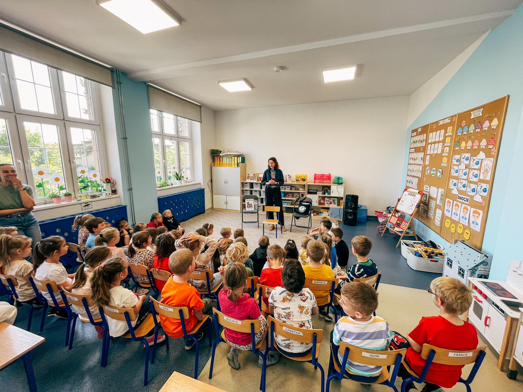 Kobieta stojąca fronet do grupy dzieci.